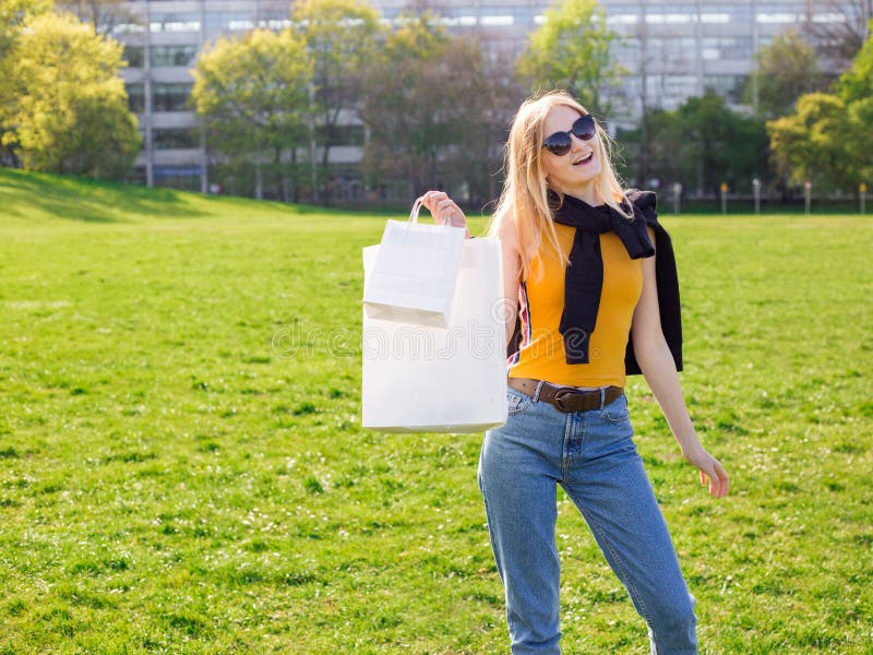 La mujer rubia hermosa con las gafas de sol disfruta de las compras Consumerismo, mofa que hace compras para arriba, concepto de fotografía de archivo libre de regalías La mujer rubia hermosa con las gafas de sol disfruta de las compras Consumerismo, mofa que hace compras para arriba, concepto de fotografía de archivo libre de regalías