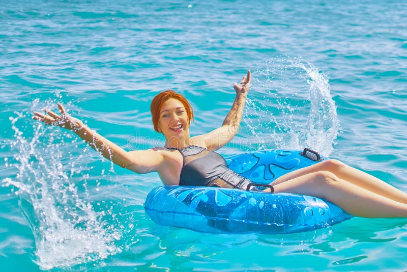 La mujer se relaja en el anillo inflable en agua de mar imágenes de archivo libres de regalías La mujer se relaja en el anillo inflable en agua de mar imágenes de archivo libres de regalías
