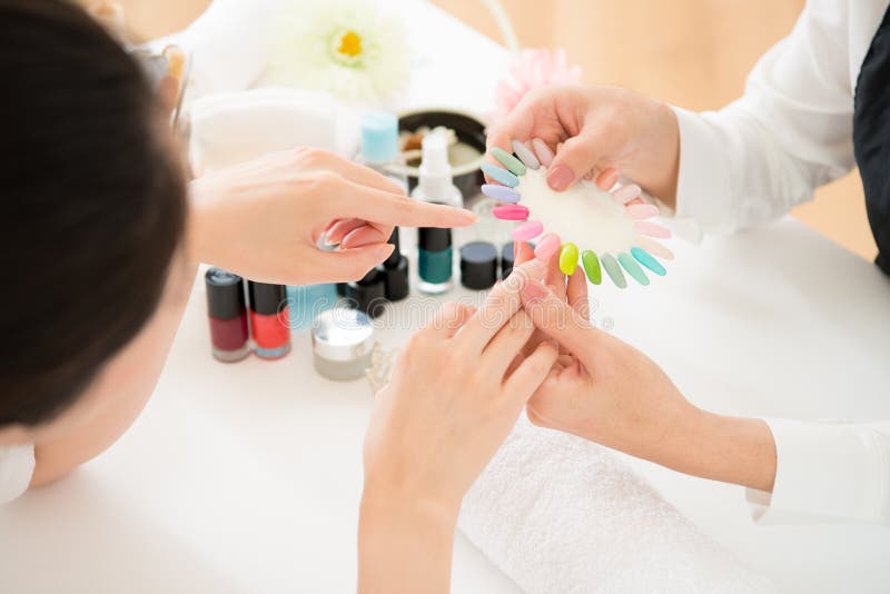 La mujer selecciona esmalte de uñas de la laca del color imagen de archivo libre de regalías La mujer selecciona esmalte de uñas de la laca del color imagen de archivo libre de regalías