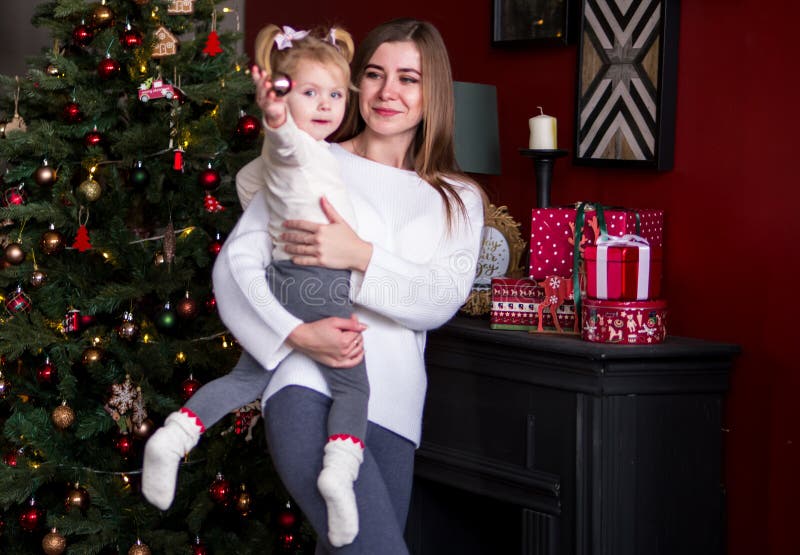 Coca Separar Cardenal La Mujer Sostiene a Su Hija Pequeña En Los Brazos, Están En Sudaderas  Blancas Interior De La Casa De Año Nuevo Árbol De Navidad, Imagen de  archivo - Imagen de mama, cabrito: