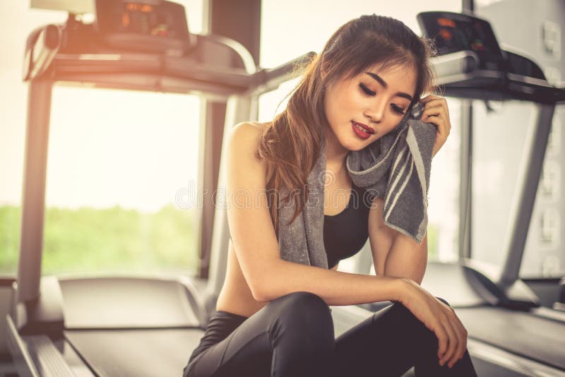 La mujer suda por la toalla durante resto en gimnasio de la aptitud con la aptitud ru fotos de archivo libres de regalías La mujer suda por la toalla durante resto en gimnasio de la aptitud con la aptitud ru fotos de archivo libres de regalías
