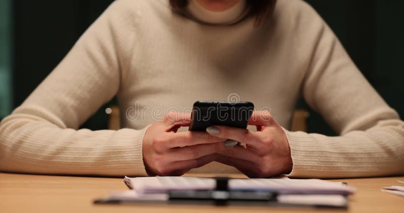 La mujer usa el teléfono por la noche en el lugar de trabajo metrajes