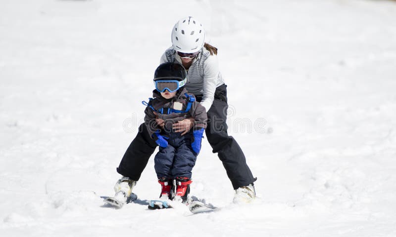 La mère aide le garçon Ski Downhill d'enfant en bas âge Habillé sans risque avec des casques images stock La mère aide le garçon Ski Downhill d'enfant en bas âge Habillé sans risque avec des casques images stock