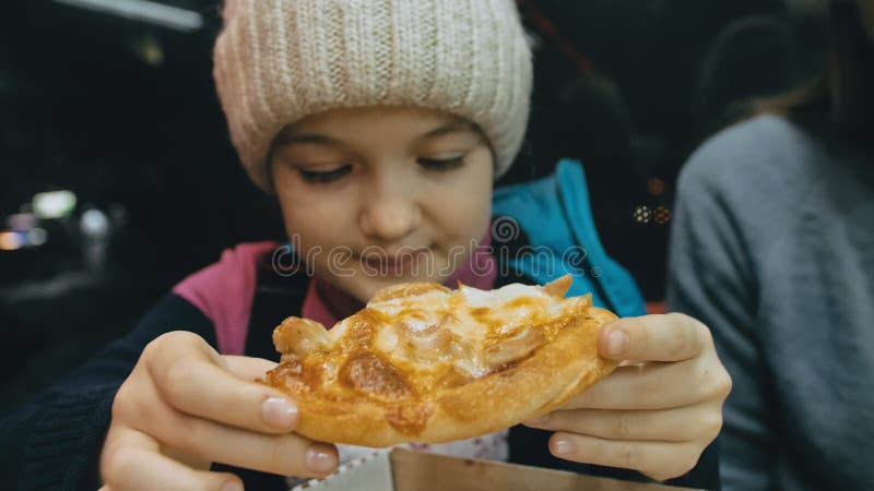 La mère et la fille mangent du fromage quatre de pizza. Proche de la jeune femme de manger de la pizza et mâchant dans le restaura banque de vidéos