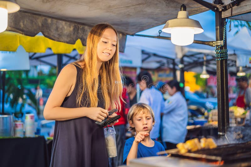 La mère et le fils sont des touristes sur le marché asiatique de marche de nourriture de rue photos libres de droits La mère et le fils sont des touristes sur le marché asiatique de marche de nourriture de rue photos libres de droits