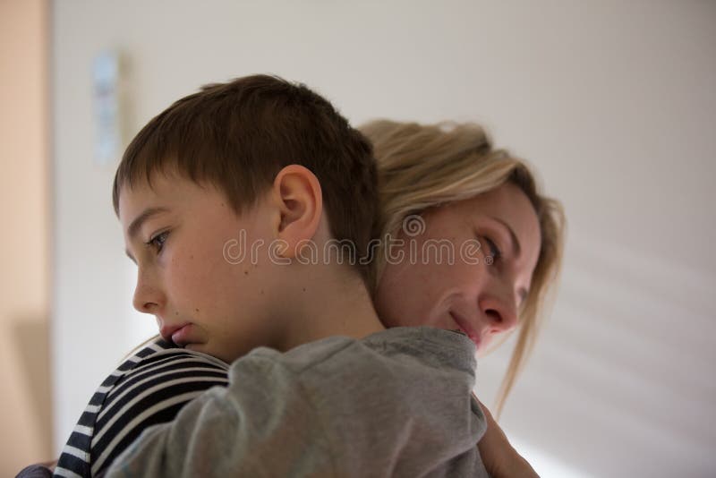 La mère et le garçon blonds de brune s'étreignent chaud D'intérieur, lumière naturelle photographie stock libre de droits La mère et le garçon blonds de brune s'étreignent chaud D'intérieur, lumière naturelle photographie stock libre de droits