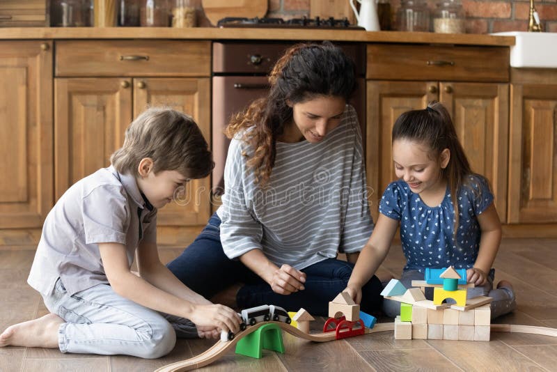 La mère ludique et les petits enfants jouent ensemble à la maison photos libres de droits