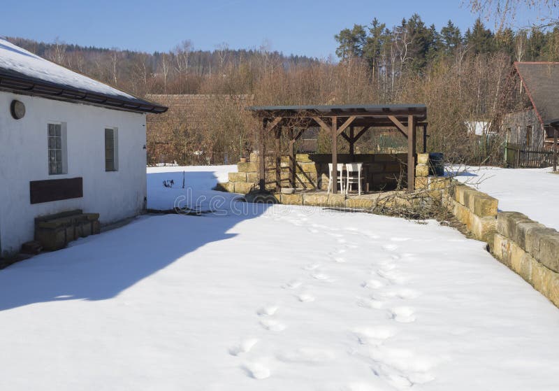 La neige a couvert le jardin dans le jour ensoleill? d'hiver de vieille maison blanche, de cottagge en bois, de mur de gr?s et d' photographie stock La neige a couvert le jardin dans le jour ensoleill? d'hiver de vieille maison blanche, de cottagge en bois, de mur de gr?s et d' photographie stock