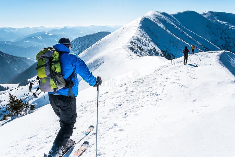 La neige de skialpinists de groupe a couvert des montagnes. Groupe de Skialpinists dans les alpes européennes, skialpinists de groupe sur les montagnes neigeuses, skialpinism de fond, touristes sur les montagnes supérieures d'hiver