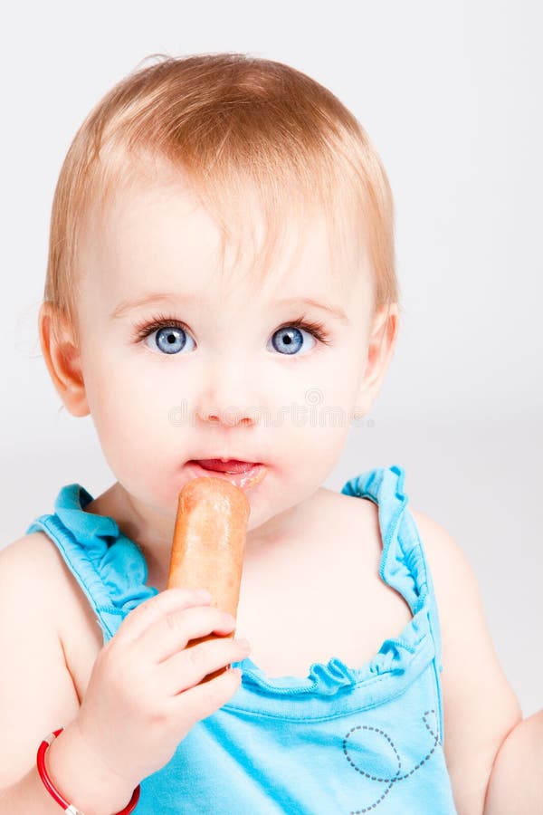 La neonata mangia il biscotto immagini stock La neonata mangia il biscotto immagini stock
