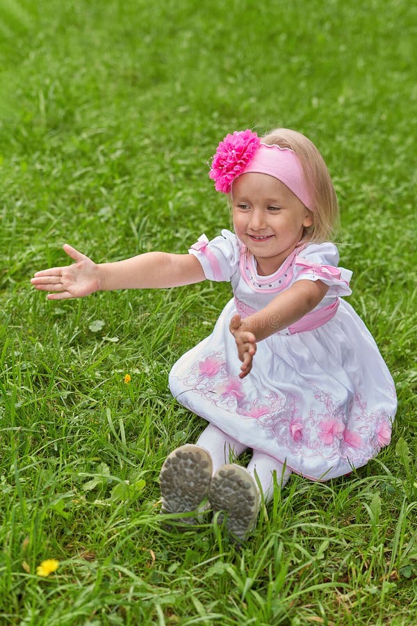 La Niña Pequeña Con Un Hermoso Vestido Se Sienta En El Pasto Y Extiende Sus Brazos Hacia Adelante Imagen de archivo - Imagen de cabrito, exterior: 198213017 La Niña Pequeña Con Un Hermoso Vestido Se Sienta En El Pasto Y Extiende Sus Brazos Hacia Adelante Imagen de archivo - Imagen de cabrito, exterior: 198213017