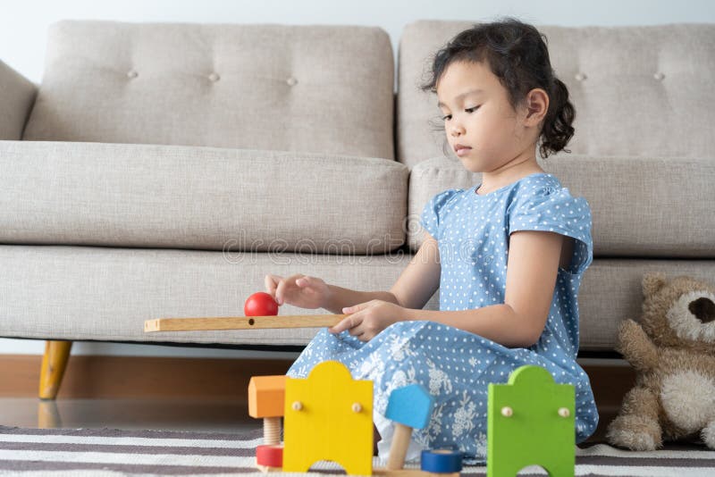 La niña asiática está jugando el juguete en la sala de estar niño joven alegre para la actividad de la libertad imagenes de archivo La niña asiática está jugando el juguete en la sala de estar niño joven alegre para la actividad de la libertad imagenes de archivo