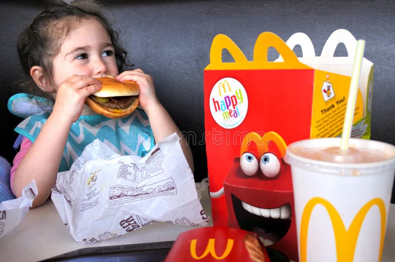La niña come los alimentos de preparación rápida fotos de archivo libres de regalías La niña come los alimentos de preparación rápida fotos de archivo libres de regalías
