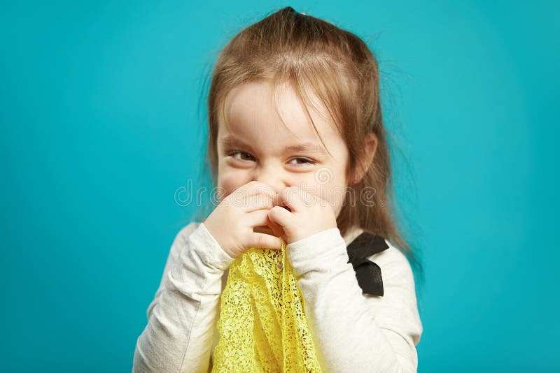 La niña de risa cubre su cara con las manos, sonrisas coqueto y tímido, expresa la vergüenza y la timidez foto de archivo libre de regalías La niña de risa cubre su cara con las manos, sonrisas coqueto y tímido, expresa la vergüenza y la timidez foto de archivo libre de regalías