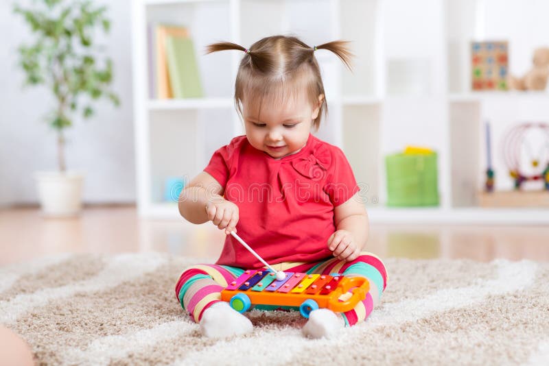 La niña del niño toca un instrumento musical foto de archivo libre de regalías