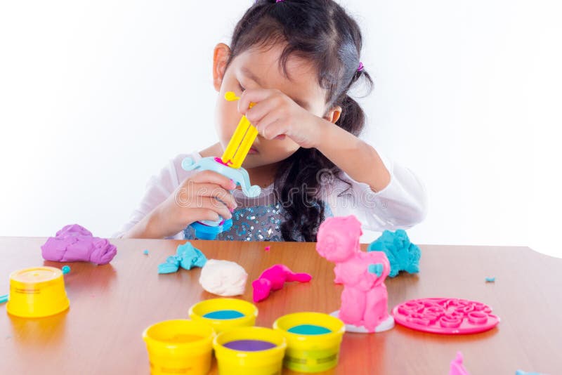 La niña está aprendiendo utilizar la pasta colorida del juego fotografía de archivo libre de regalías La niña está aprendiendo utilizar la pasta colorida del juego fotografía de archivo libre de regalías