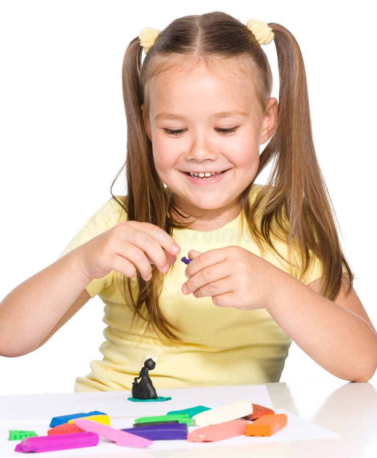 La niña está jugando con plasticine fotos de archivo La niña está jugando con plasticine fotos de archivo