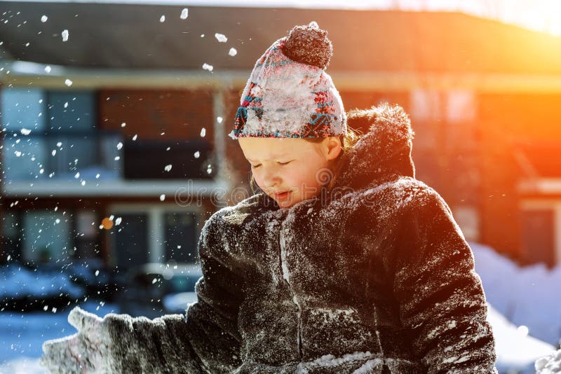 La niña feliz en las manoplas blancas que camina en el parque del invierno lanza para arriba nieve fotos de archivo libres de regalías La niña feliz en las manoplas blancas que camina en el parque del invierno lanza para arriba nieve fotos de archivo libres de regalías