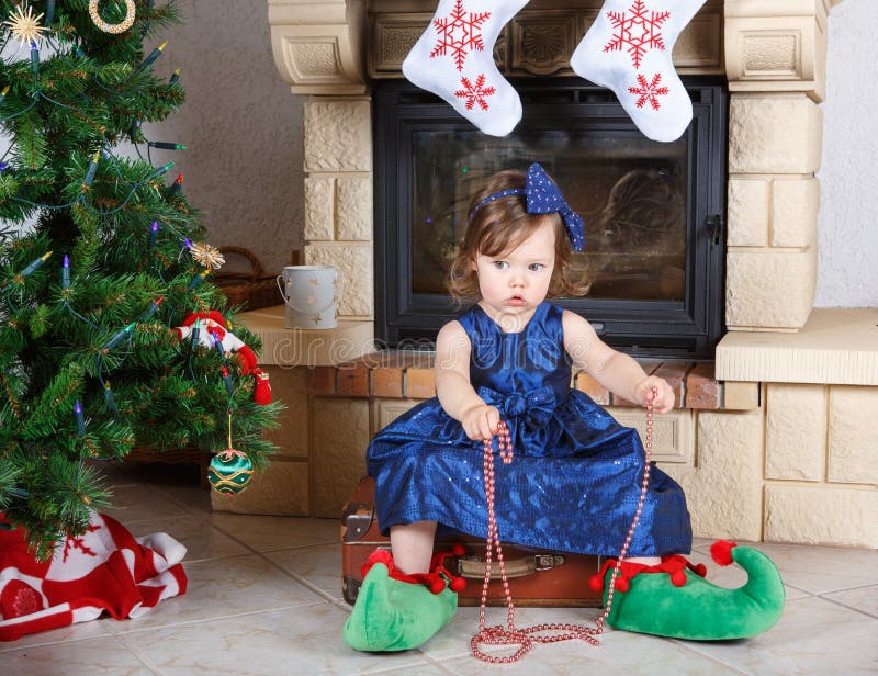 La niña feliz en los zapatos de santa tiene una Navidad. fotos de archivo La niña feliz en los zapatos de santa tiene una Navidad. fotos de archivo
