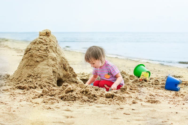 La niña linda construye una casa fuera de la arena imagen de archivo La niña linda construye una casa fuera de la arena imagen de archivo