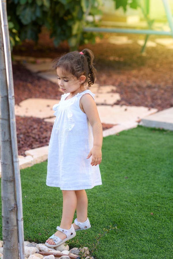 La niña linda de 3 años en la clase de la naturaleza del parque, mirando, observa para los componentes del árbol fotografía de archivo La niña linda de 3 años en la clase de la naturaleza del parque, mirando, observa para los componentes del árbol fotografía de archivo