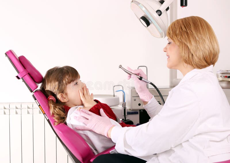 La niña tiene miedo del dentista fotografía de archivo La niña tiene miedo del dentista fotografía de archivo