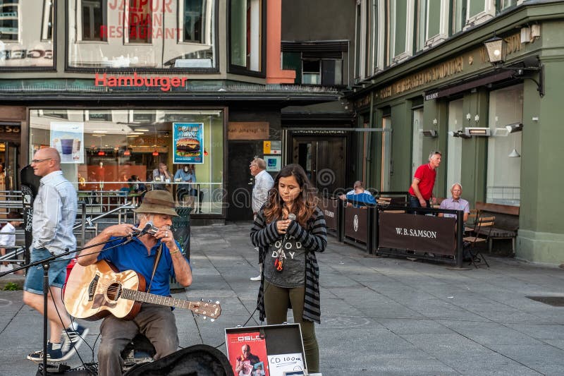 La Norvegia, Oslo 1? agosto 2013 Musicista e ragazza che cantano nel quadrato a Oslo, la capitale della Norvegia Reddito extra pe fotografia stock La Norvegia, Oslo 1? agosto 2013 Musicista e ragazza che cantano nel quadrato a Oslo, la capitale della Norvegia Reddito extra pe fotografia stock