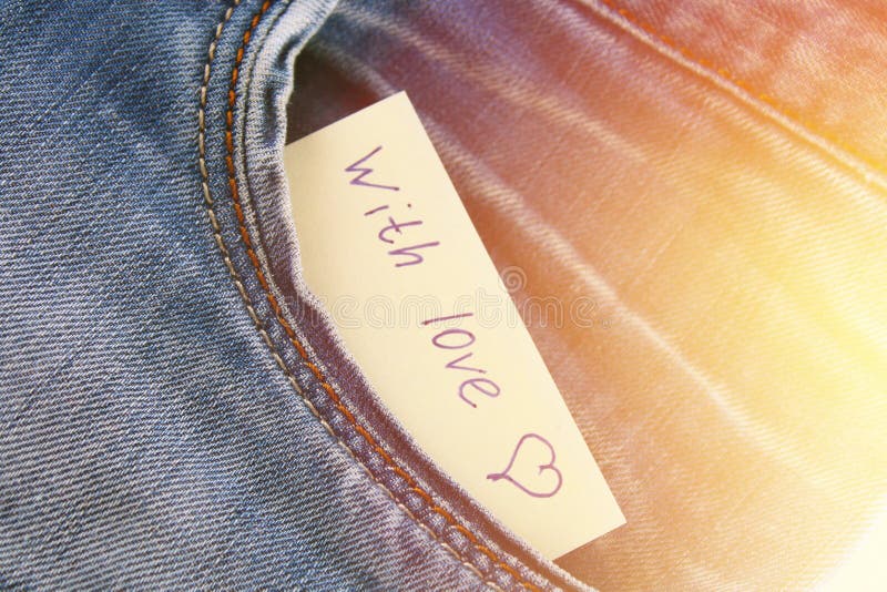 La nota di carta con l'iscrizione ti amo, con amore sbircia dalla tasca dei pantaloni dei jeans Il concetto del giorno degli aman immagine stock La nota di carta con l'iscrizione ti amo, con amore sbircia dalla tasca dei pantaloni dei jeans Il concetto del giorno degli aman immagine stock