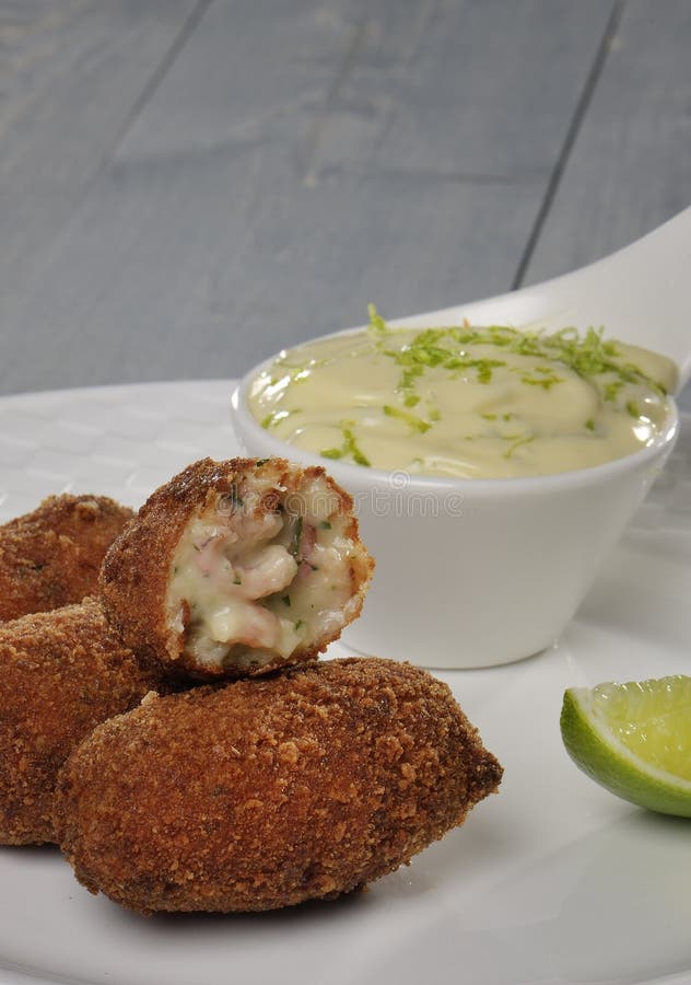 Scrimp croquette with llime mayonnaisse on a white plate. Scrimp croquette with llime mayonnaisse on a white plate