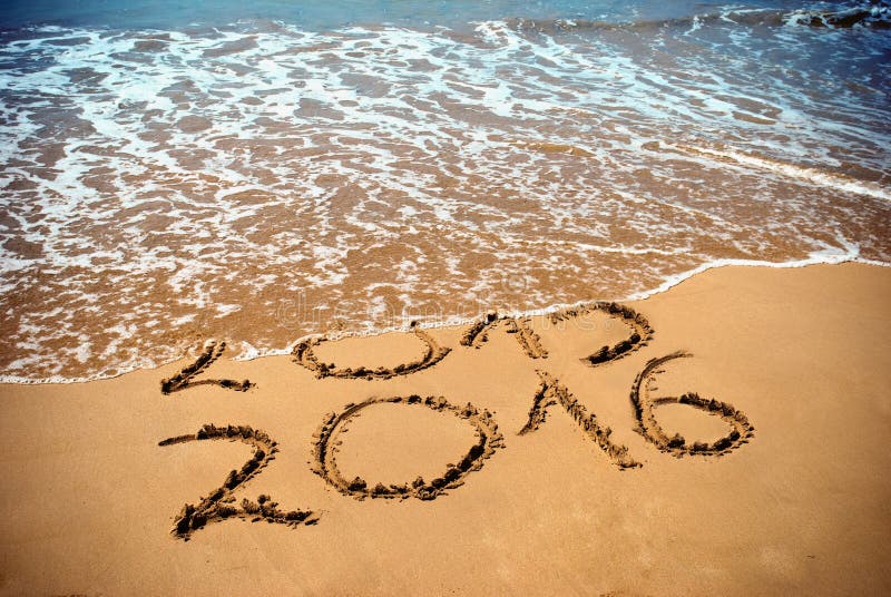 New Year 2016 is coming concept - inscription 2015 and 2016 on a beach sand, the wave is covering digits 2015. New Year 2016 is coming concept - inscription 2015 and 2016 on a beach sand, the wave is covering digits 2015