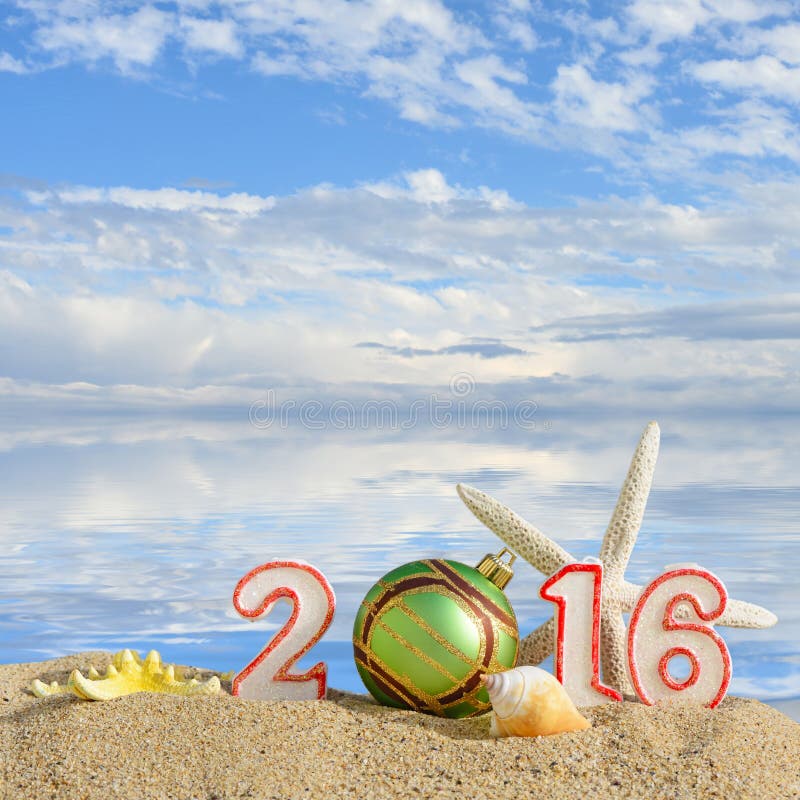 New year 2016 sign on a beach sand with seashells, starfish and christmas ball. New year 2016 sign on a beach sand with seashells, starfish and christmas ball