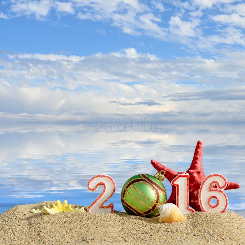New year 2016 sign on a beach sand with seashells, starfish and christmas ball. New year 2016 sign on a beach sand with seashells, starfish and christmas ball