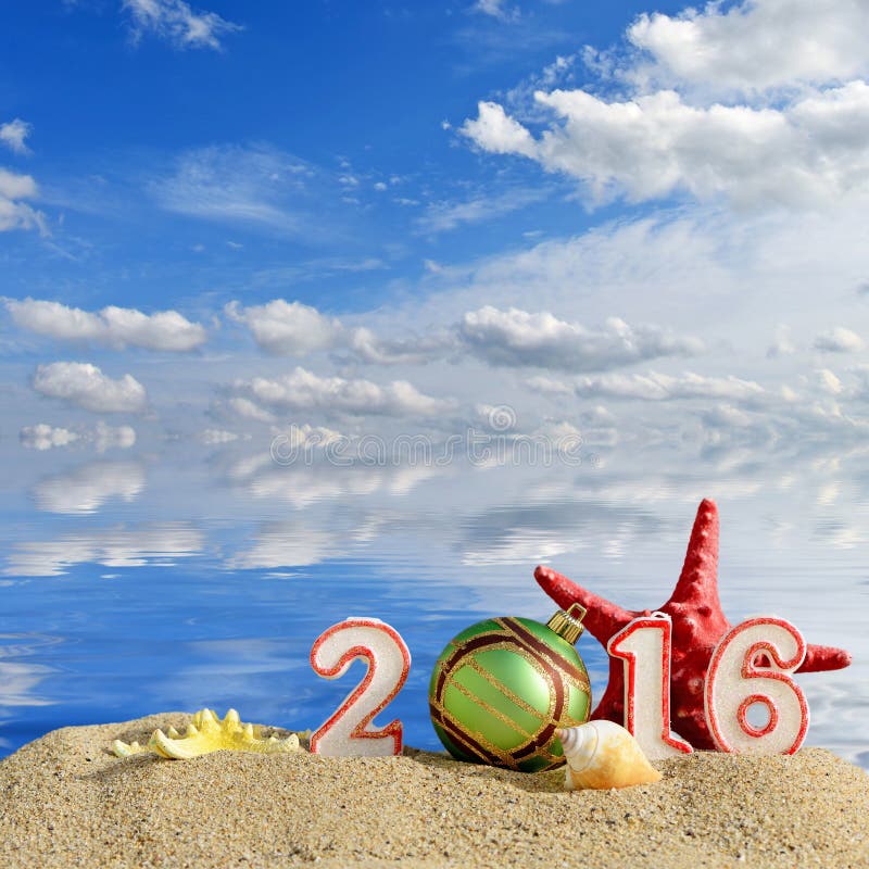 New year 2016 sign on a beach sand with seashells, starfish and christmas ball. New year 2016 sign on a beach sand with seashells, starfish and christmas ball