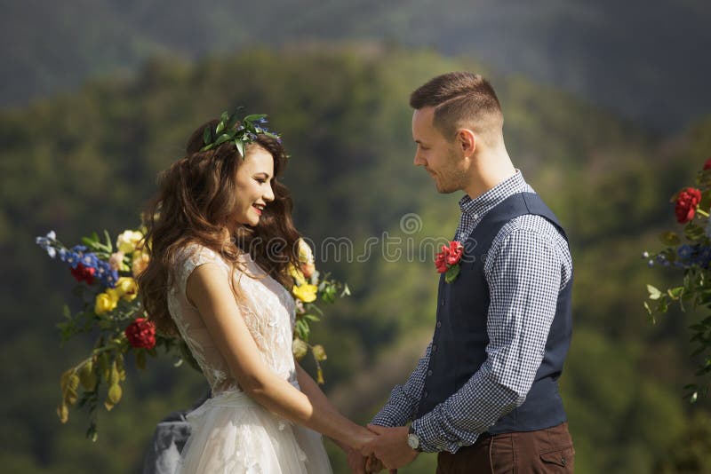 La novia y el novio en el fondo de una montaña fluyen imagenes de archivo