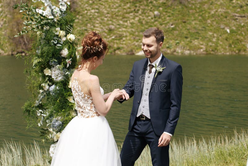 La novia y el novio en el fondo de una montaña fluyen imagenes de archivo