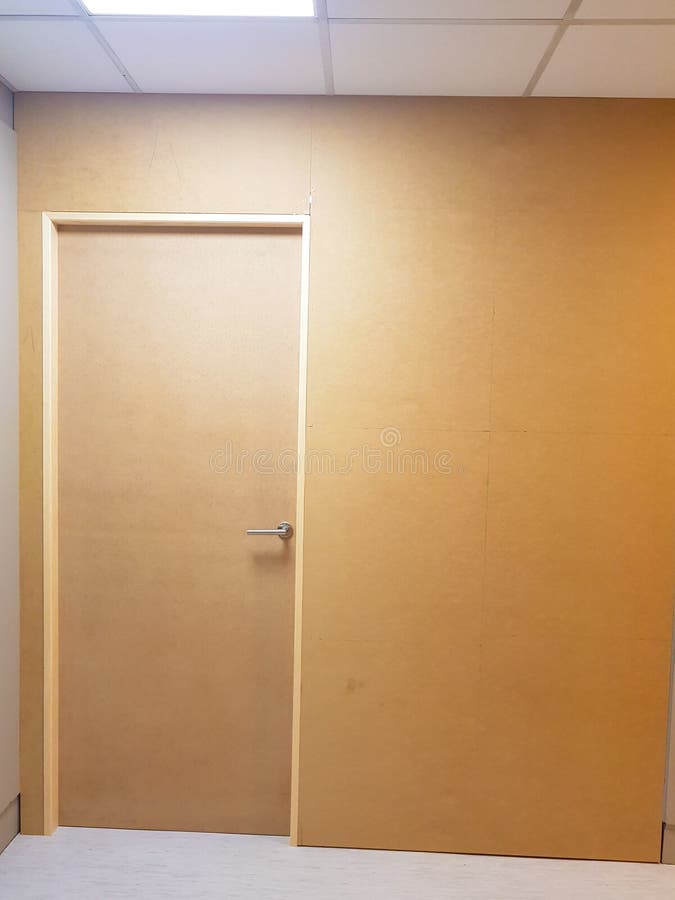 La parete ha dipinto marrone con la porta di legno inoltre marrone da un lato Vista frontale del tutto fotografia stock libera da diritti La parete ha dipinto marrone con la porta di legno inoltre marrone da un lato Vista frontale del tutto fotografia stock libera da diritti