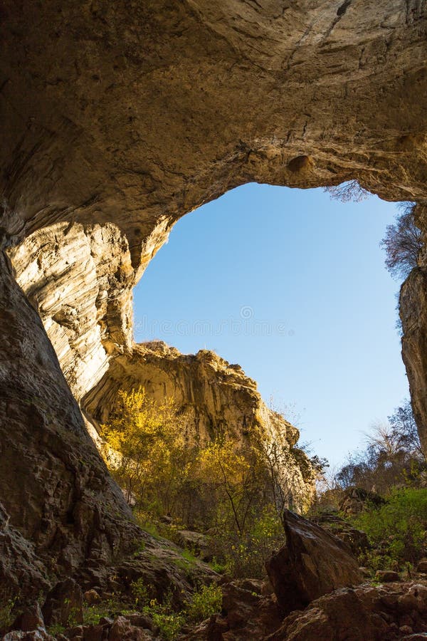 La parte de la cueva y el cielo azul vibrante en Prohodna excavan, Bulgaria fotografía de archivo La parte de la cueva y el cielo azul vibrante en Prohodna excavan, Bulgaria fotografía de archivo