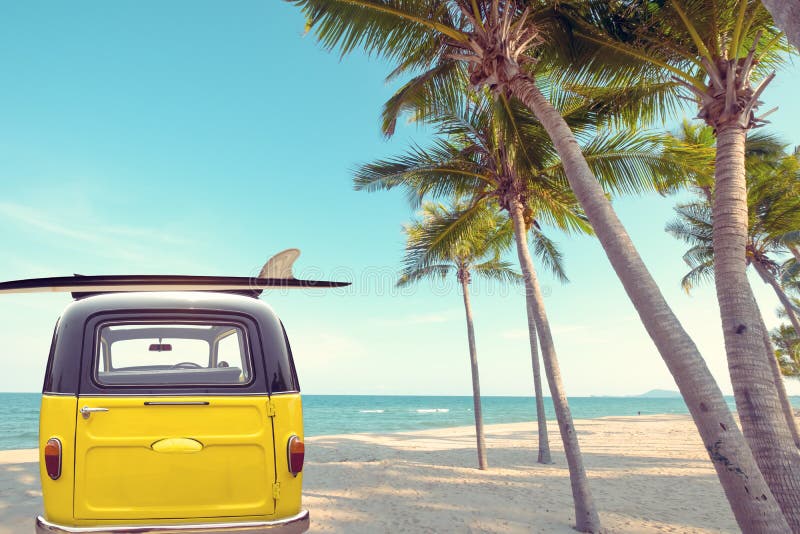 La parte posteriore dell'automobile d'annata ha parcheggiato sulla spiaggia tropicale della spiaggia con un surf sul tetto immagine stock libera da diritti La parte posteriore dell'automobile d'annata ha parcheggiato sulla spiaggia tropicale della spiaggia con un surf sul tetto immagine stock libera da diritti