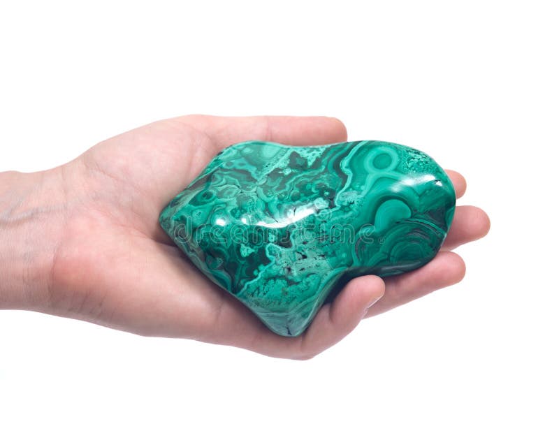 Woman`s hand holding polished malachite free form isolated on white background. Woman`s hand holding polished malachite free form isolated on white background