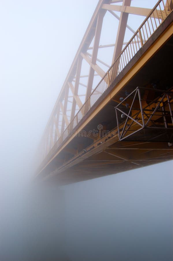 La passerelle jaune disparaît dans le regain épais d'automne photo stock