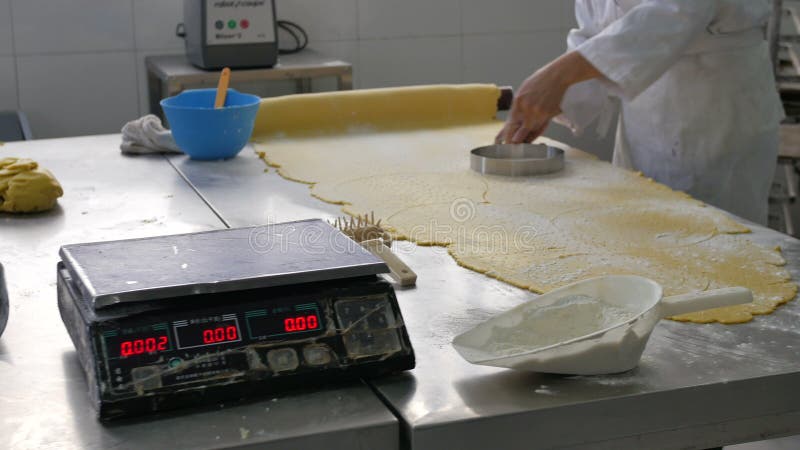 La pasta del corte del trabajador de la panadería circunda en panadería industrial