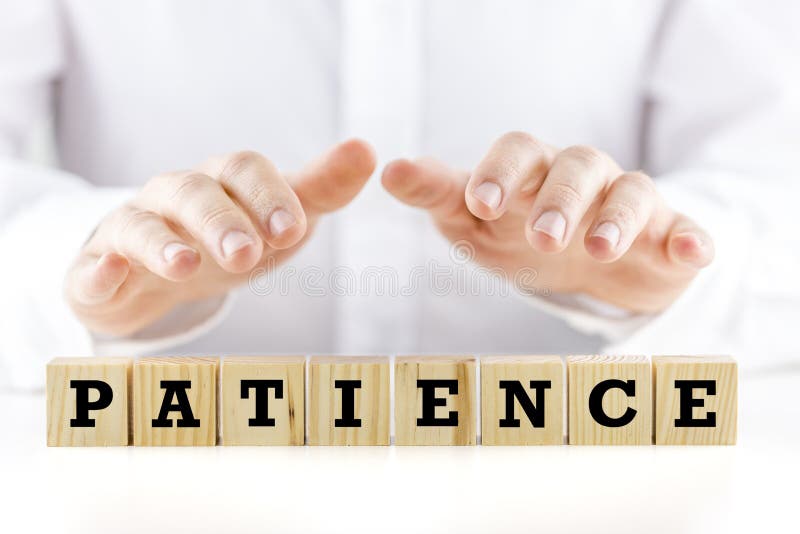 Conceptual image with the word Patience on wooden blocks or cubes protected by the hands of a man sheltering them from above. Conceptual image with the word Patience on wooden blocks or cubes protected by the hands of a man sheltering them from above