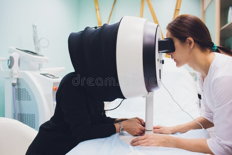 La peau de visage analysent Peau d'Analyzing Woman Facial de Cosmetologist image stock La peau de visage analysent Peau d'Analyzing Woman Facial de Cosmetologist image stock