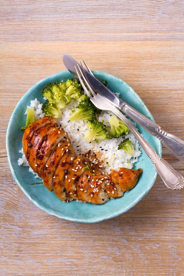 La pechuga de pollo en vinagre balsámico y el azúcar marrón sauce asperjado con las semillas de sésamo Pollo con arroz y bróculi imagen de archivo La pechuga de pollo en vinagre balsámico y el azúcar marrón sauce asperjado con las semillas de sésamo Pollo con arroz y bróculi imagen de archivo