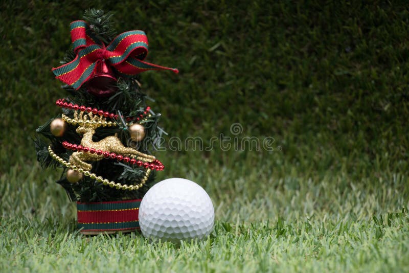 Golf ball is on Christmas tree ornament are on green grass. Golf ball is on Christmas tree ornament are on green grass