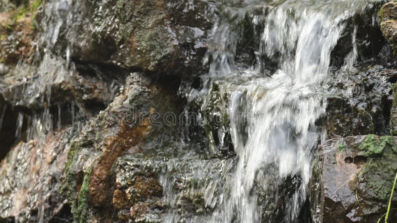 La pequeña cascada. tiro al fondo de agua entrando por las rocas almacen de metraje de vídeo