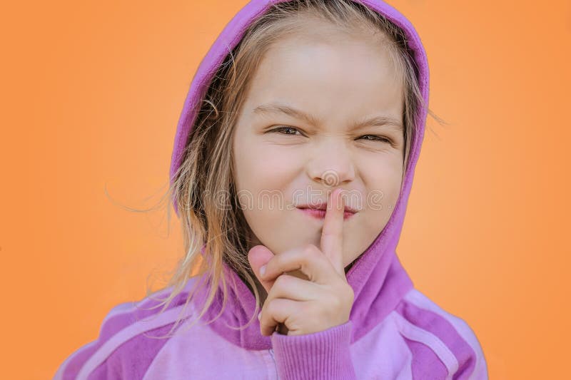 La pequeña muchacha sonriente introduce el índice a los labios imágenes de archivo libres de regalías La pequeña muchacha sonriente introduce el índice a los labios imágenes de archivo libres de regalías