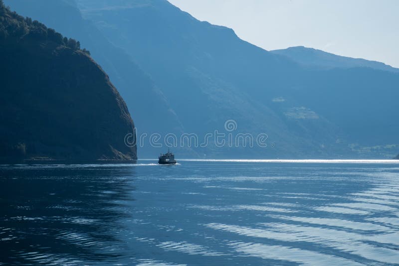 La pequeña nave navega en agua azul con mountais grandes Paisaje de Noruega, travesía del fiordo fotografía de archivo libre de regalías La pequeña nave navega en agua azul con mountais grandes Paisaje de Noruega, travesía del fiordo fotografía de archivo libre de regalías