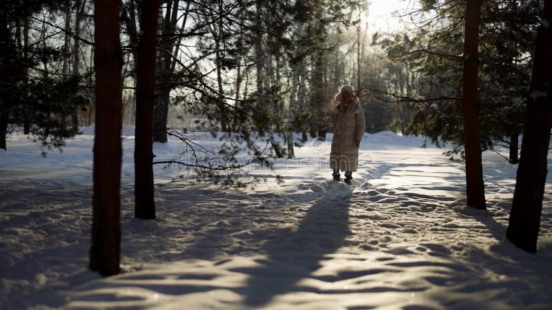 La persona cammina in una foresta di neve durante il giorno invernale guardando alberi e godendo di aria fresca archivi video