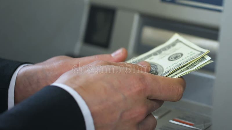 La persona del negocio que cuenta dólares acerca a la atmósfera y dinero el poner en la cartera, depositando